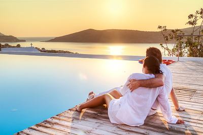 Couple gazes at sunset by the pool